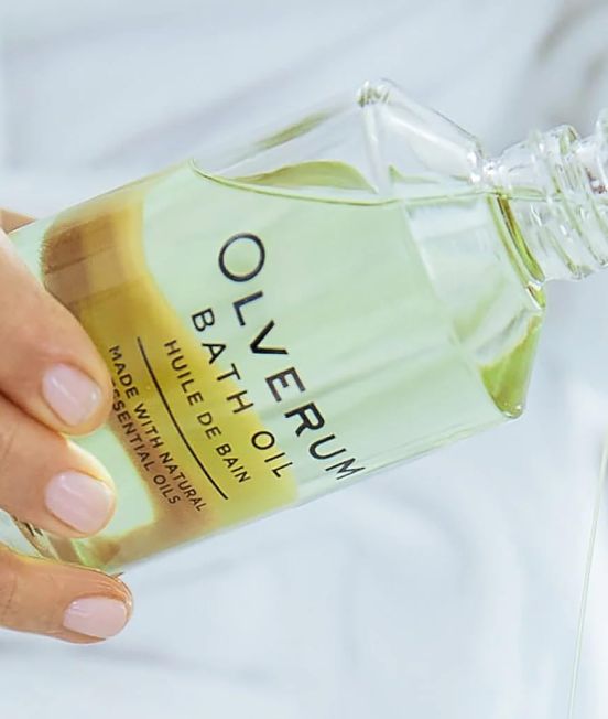 Pouring from a bottle of Olverum Bath Oil