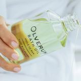 Pouring from a bottle of Olverum Bath Oil