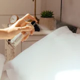 Spraying from a bottle of Olverum Restful Pillow Mist- A great aid to restful sleep